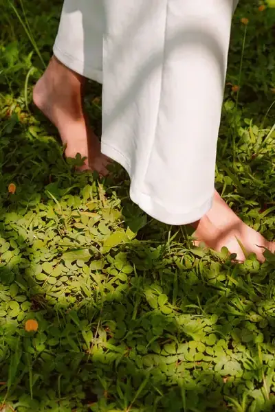 Bare feet walking through cool green grass in daylight