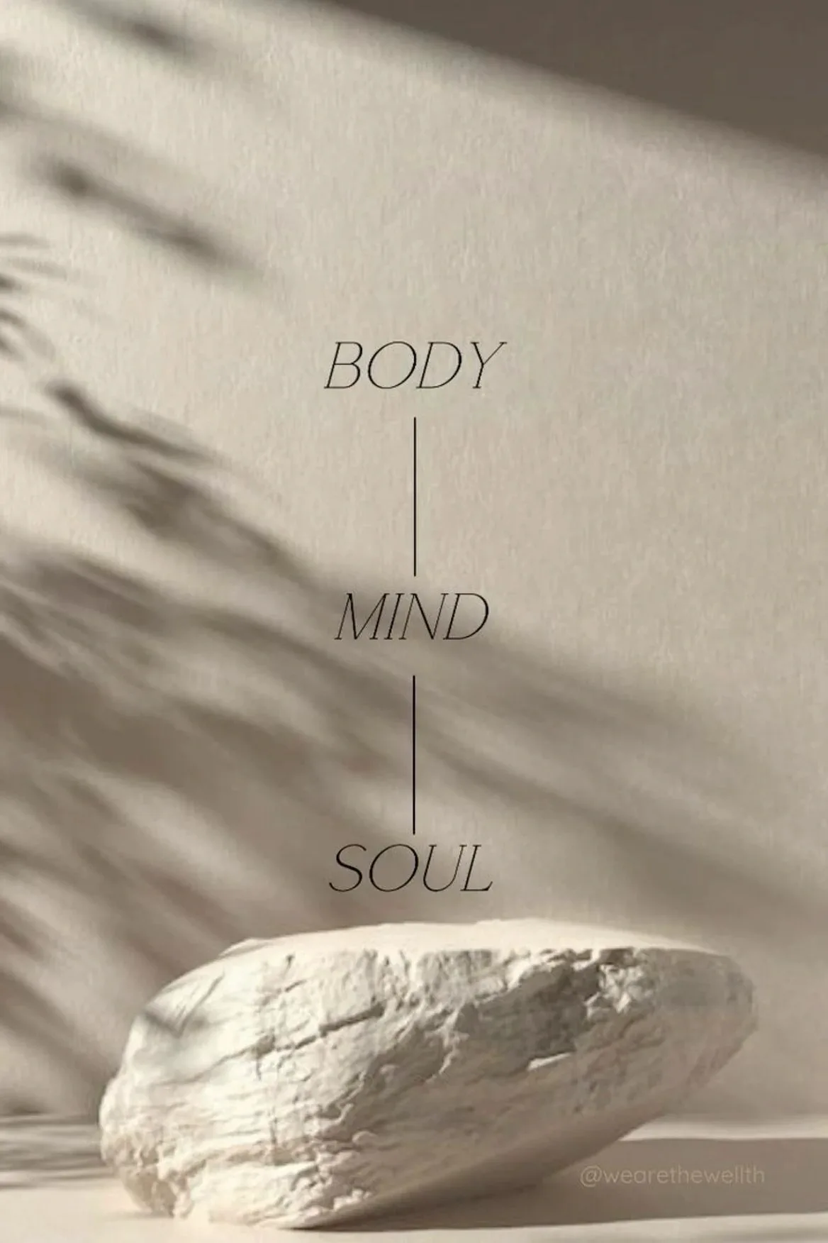 A pale stone in soft light beneath the words body, mind, soul