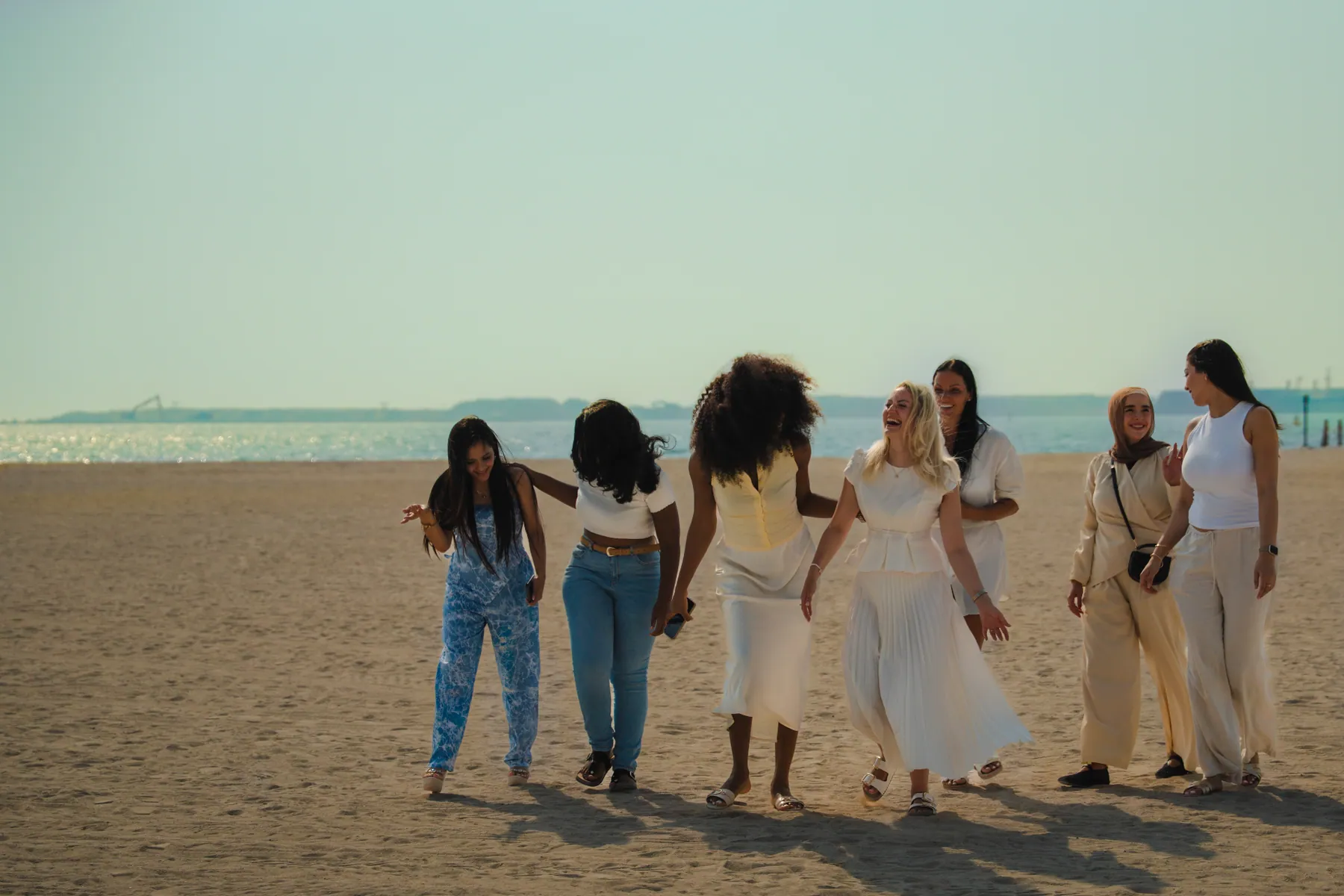 A group of Hormone Method clients walking together on the beach
