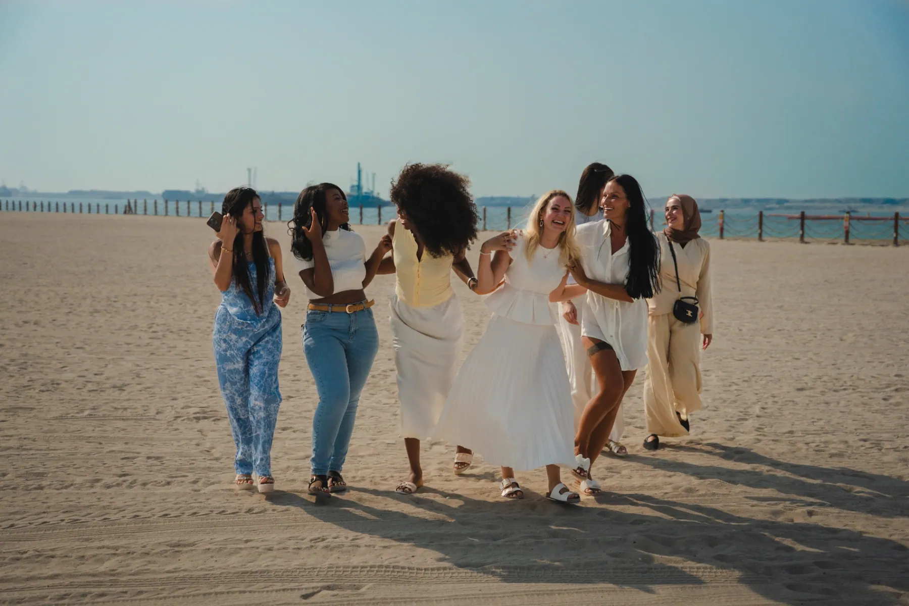 A group of women supported by The Hormone Method walking together on the beach